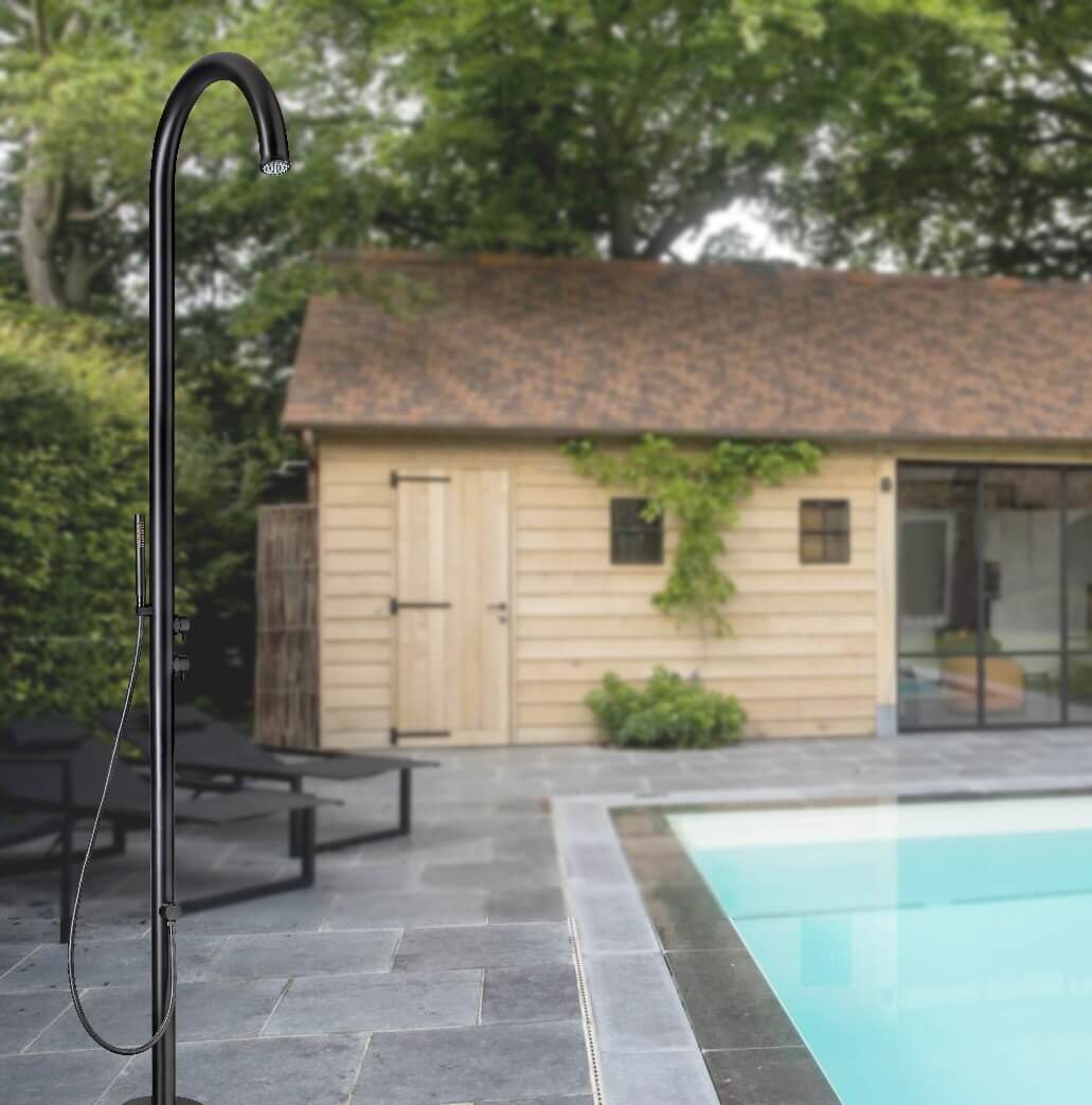 Černá sprcha Cometa s ruční sprchou stojicí u bazénu před zahradním domkem.