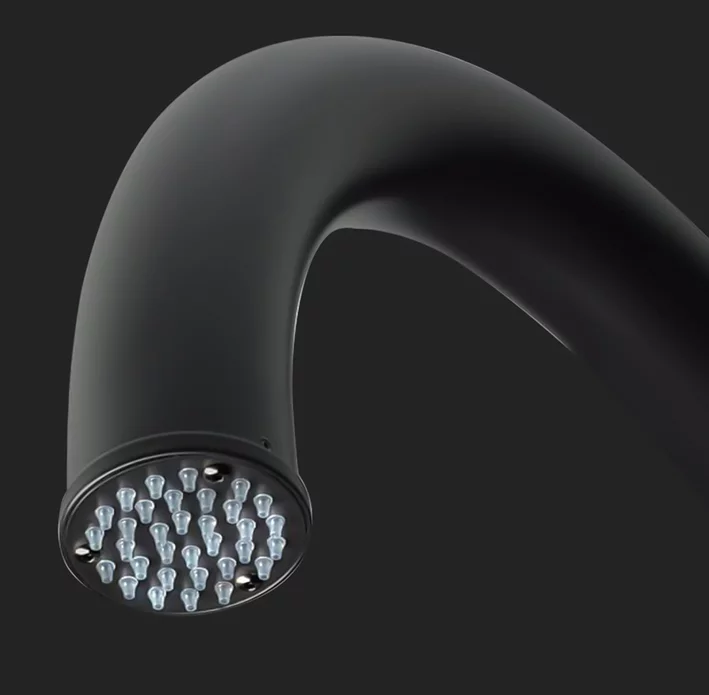 Detail nerezové černé sprchové  hlavice se silikonovými tryskami.